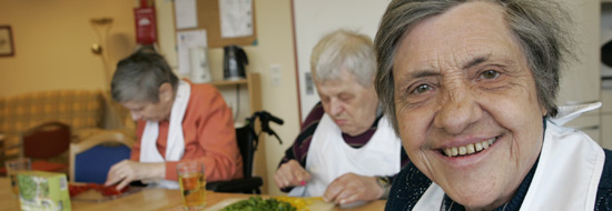 Auf dem Bild ist eine Gruppe älterer Menschen zu sehen, die gemeinsam im Haus Smyrna kochen.